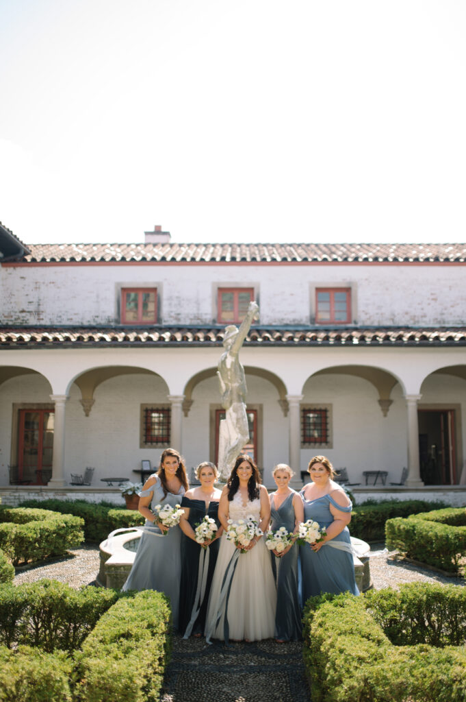 bride and her bridesmaids in different shades of blue dresses at villa terrace in Milwaukee Wisconsin